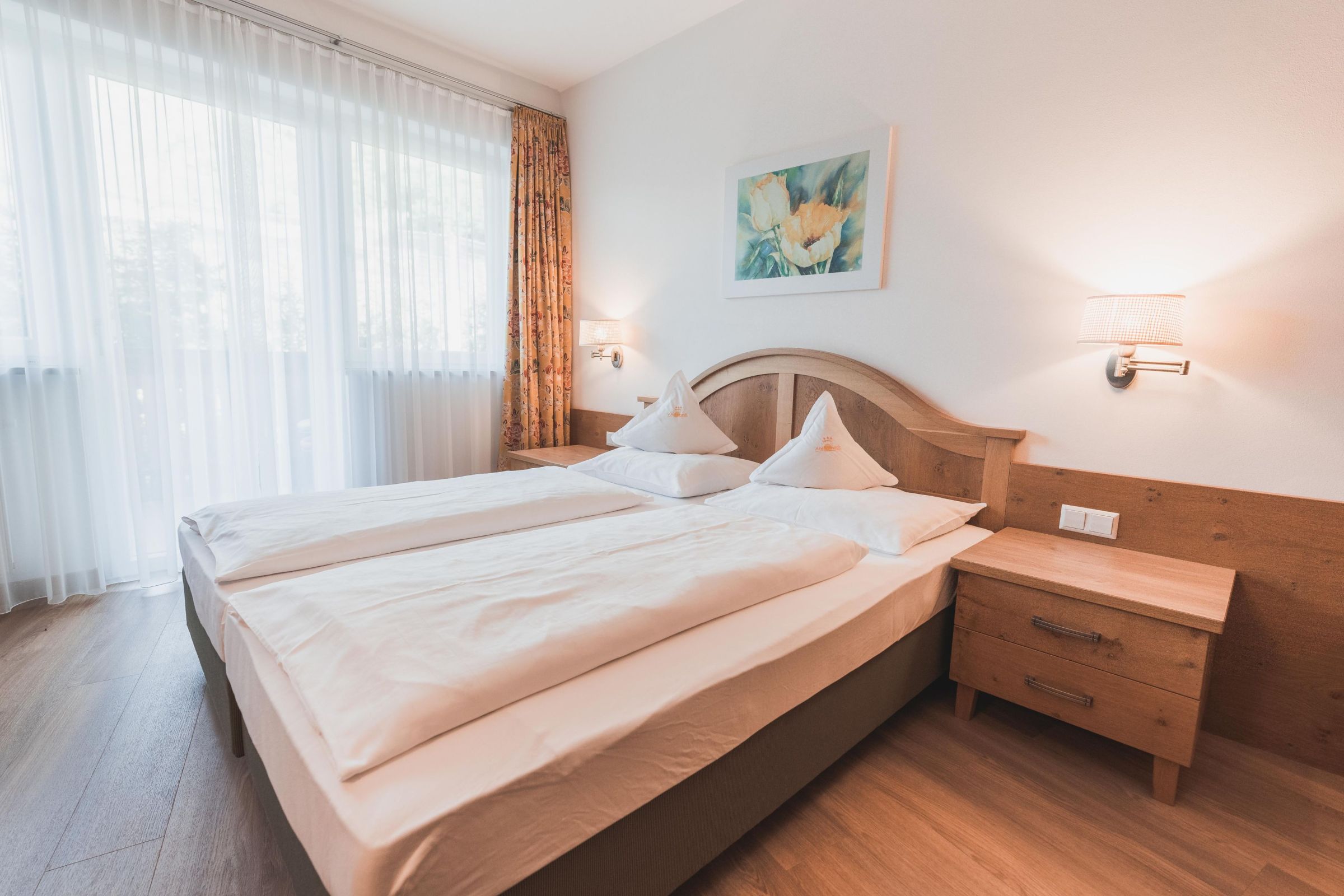 Gemütlicher Schlafbereich im Doppelzimmer Vellau – Hotel Am Sonneck