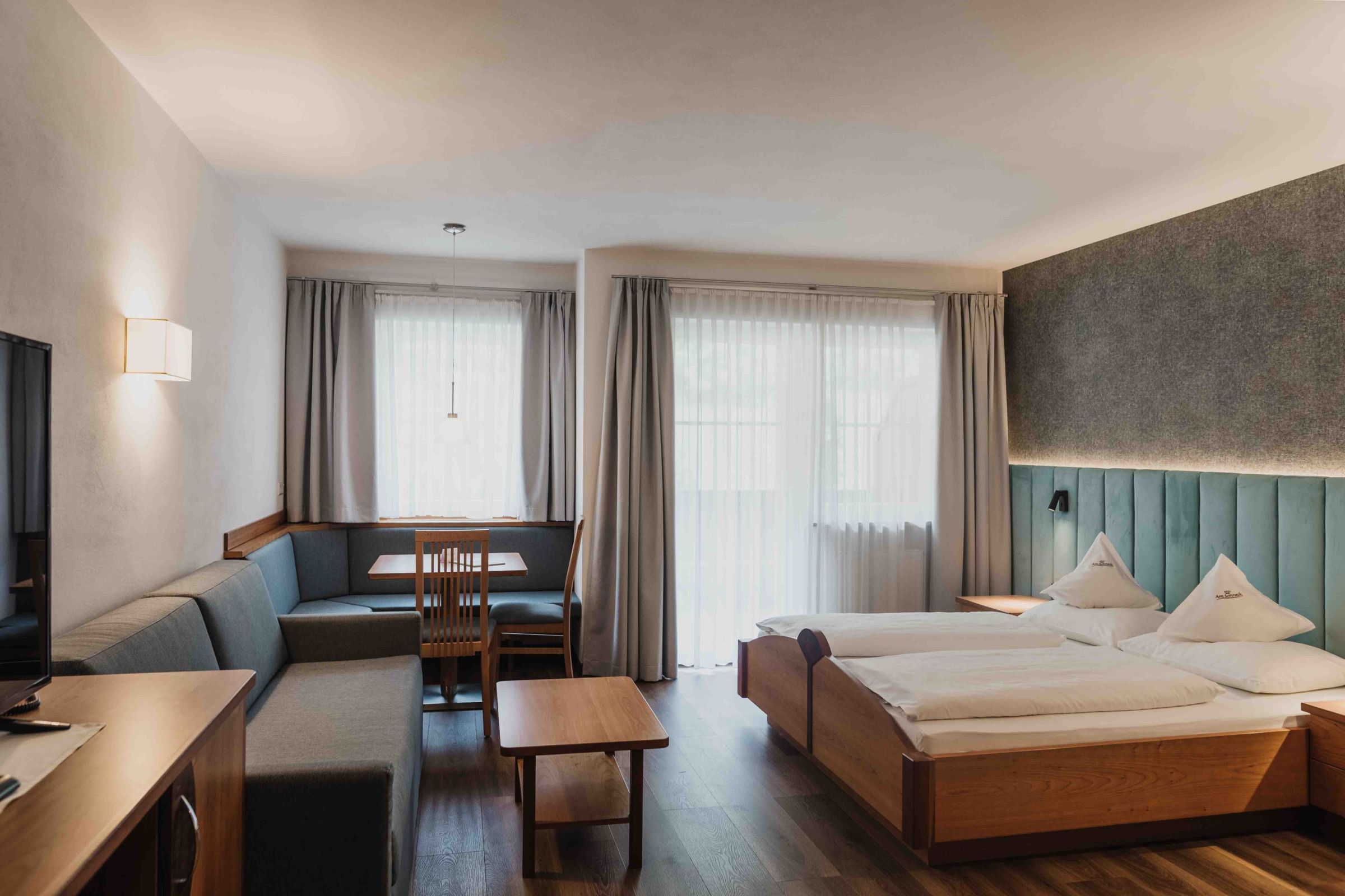Modernes Doppelzimmer Rosenduft mit Doppelbett und Sitzecke – Hotel Am Sonneck